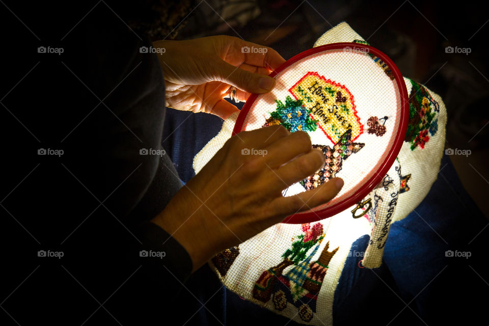 Woman doing stitching embroidery at night - love this hobby. Home sweet home needlework scene is so fitting during Covid lockdown!