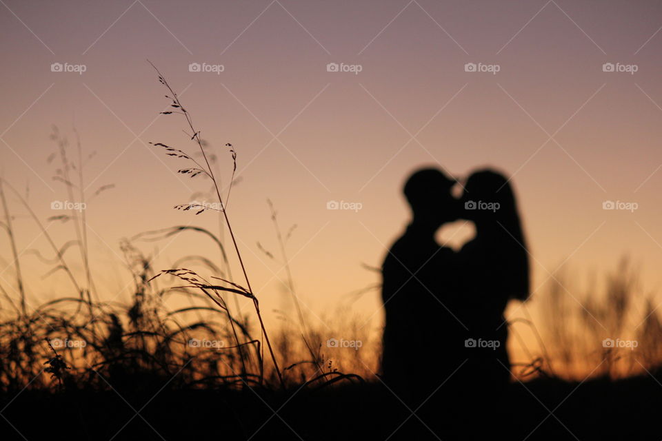 A couple creates a heart at sunset