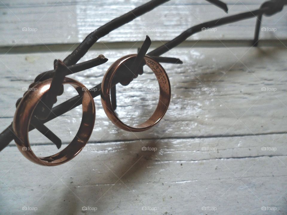 two wedding rings on barbed wire