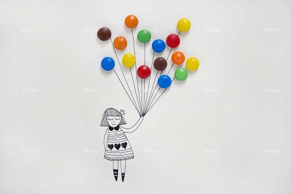 An illustration of a girl holding real colorful candies like balloons