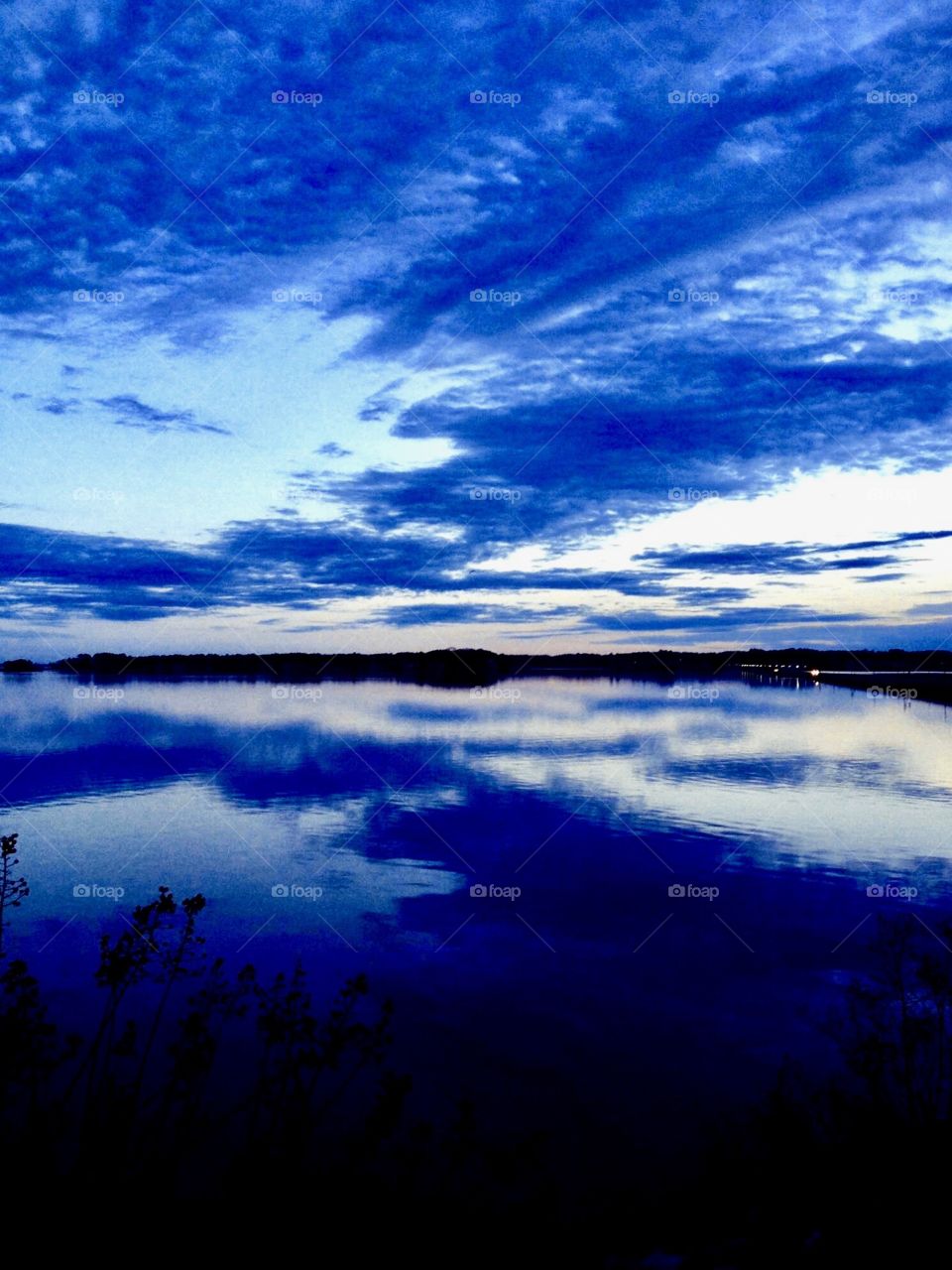 Vibrant clouds reflected in water at dusk