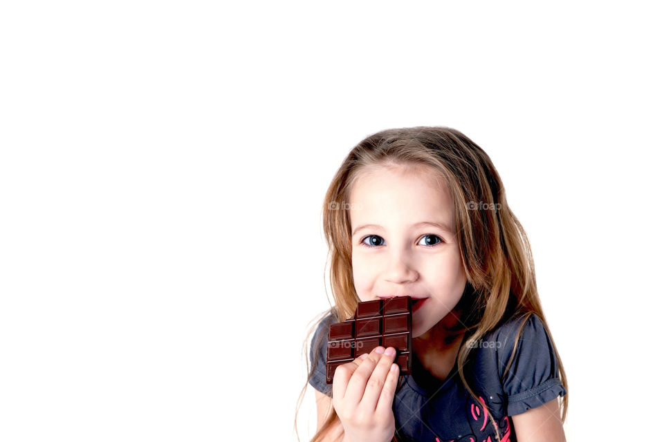 Cute smiling girl eating chocolate