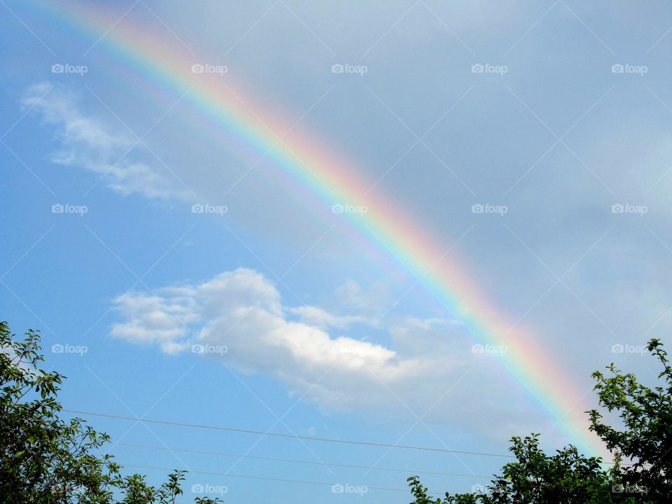 rainbow in the sky in July, hot weather, rain soon