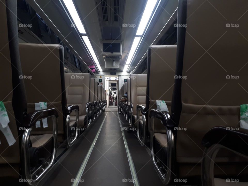 The design of the light brown colored train passenger seats on the train looks empty in the morning