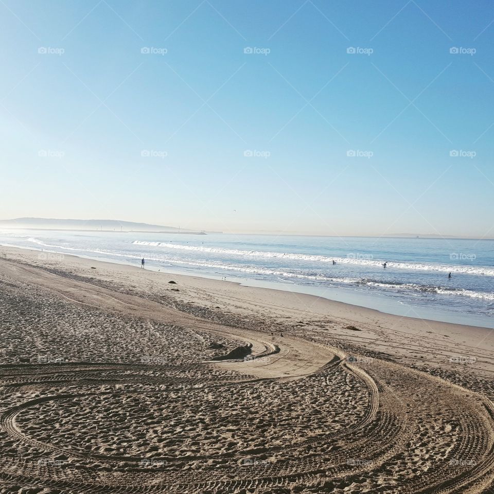 beach at sunrise with tire tracks