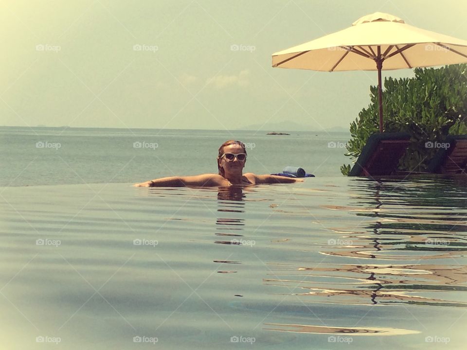 Woman relaxing in infinity pool