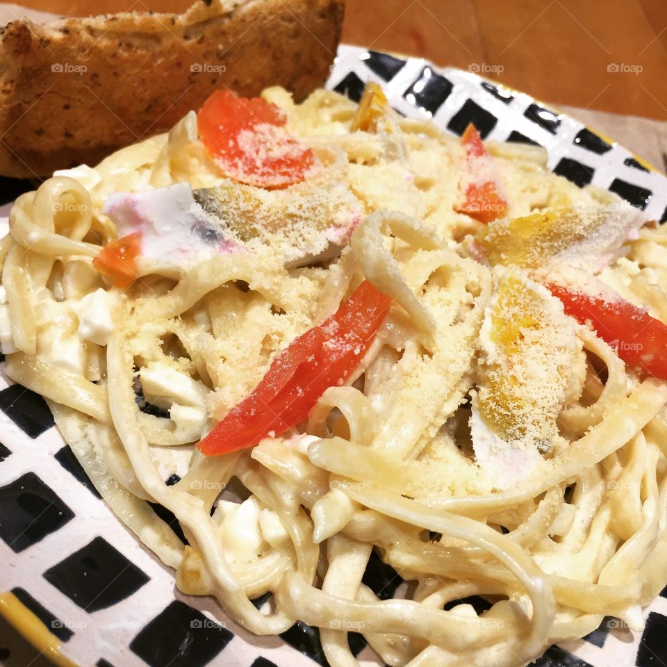 Creamy pasta topped with slices of fresh tomatoes, salted egg, and grated parmesan cheese.