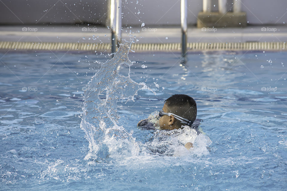 Asean boys are swimming in the pool.