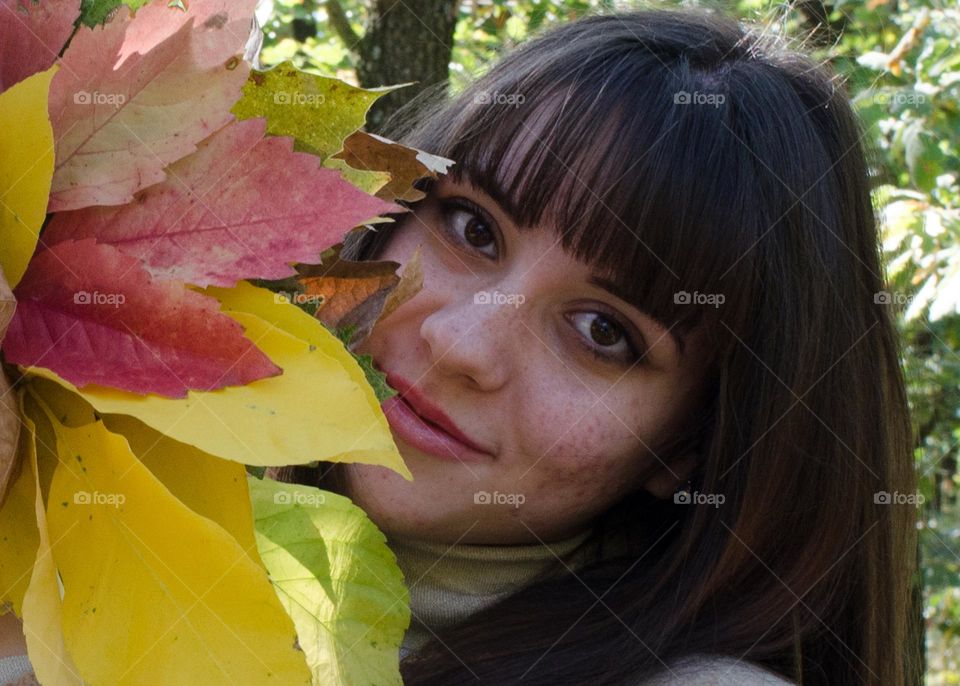 Smiling Young Girl on Autumn Background