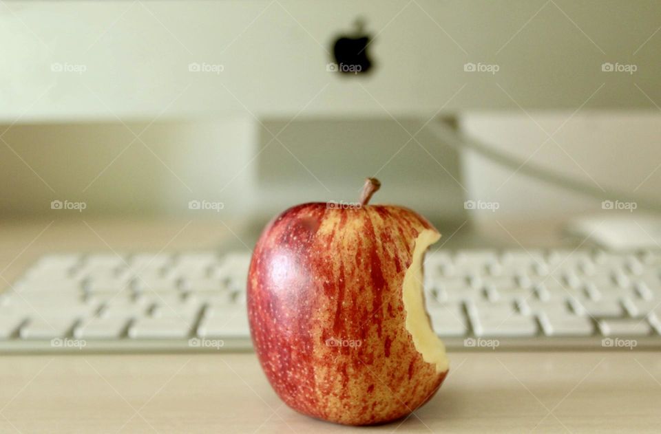 close-up of a bitten apple in front of the Apple computer