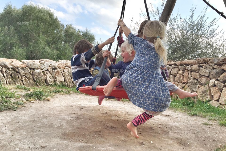 Close-up of children playing together on swing
