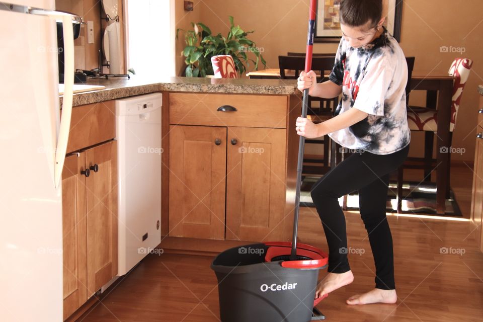 Girl using O-Cedar mop and bucket 