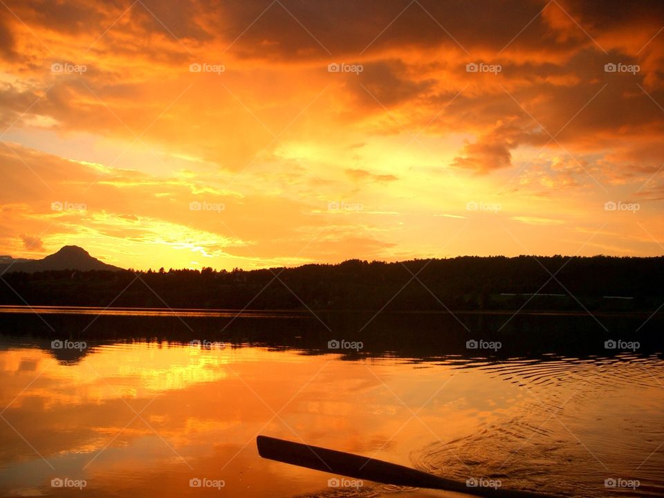 Reflection of dramatic sky in lake at sunset