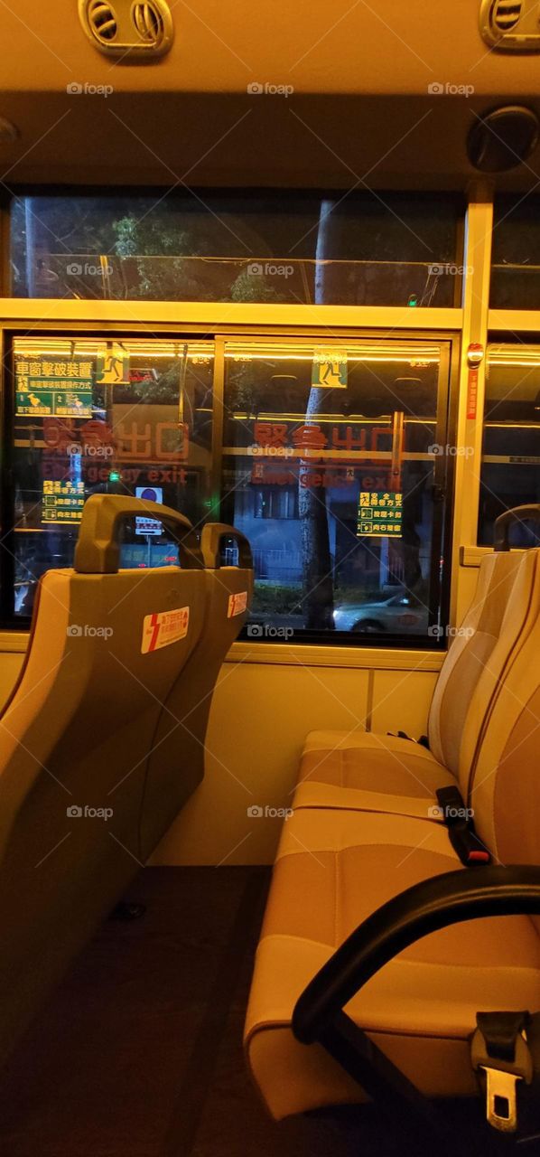 A retro-style bus with a warm yellow light interior.Safety equipment window breakers.bus seat