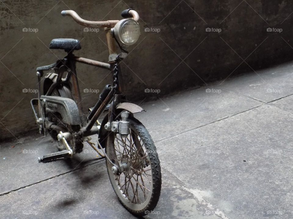 Old, rusty and broken toy bicycle