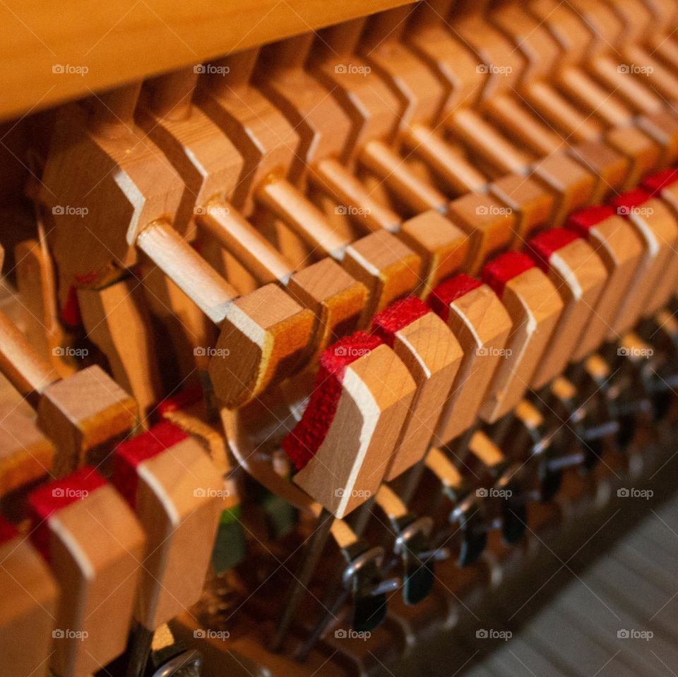 The heart of a piano. Warm padded wooden hammers inside an upright piano waiting to be played.