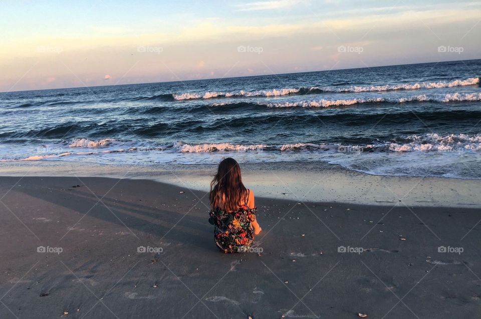 Girl sitting by Ocean