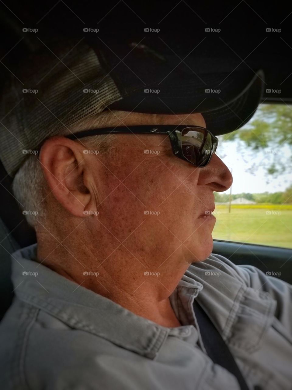 A man driving wearing sunglasses