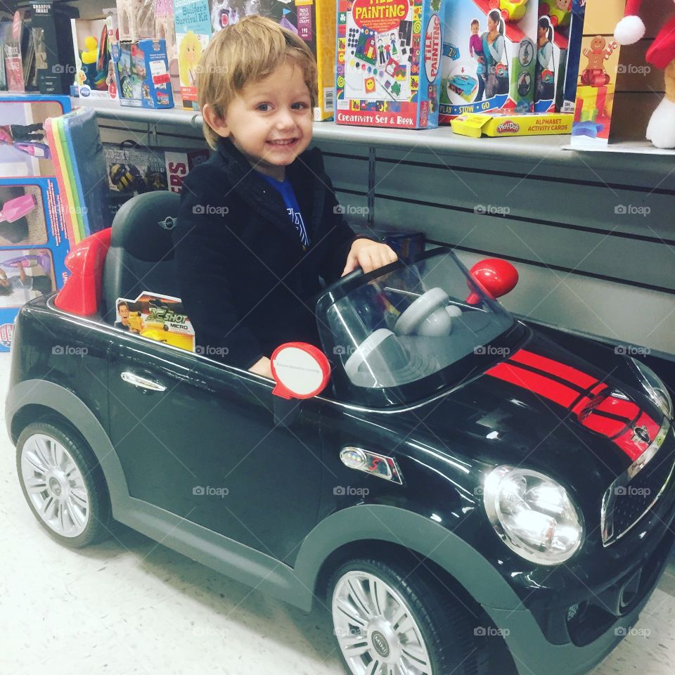 Boy sitting in toy car