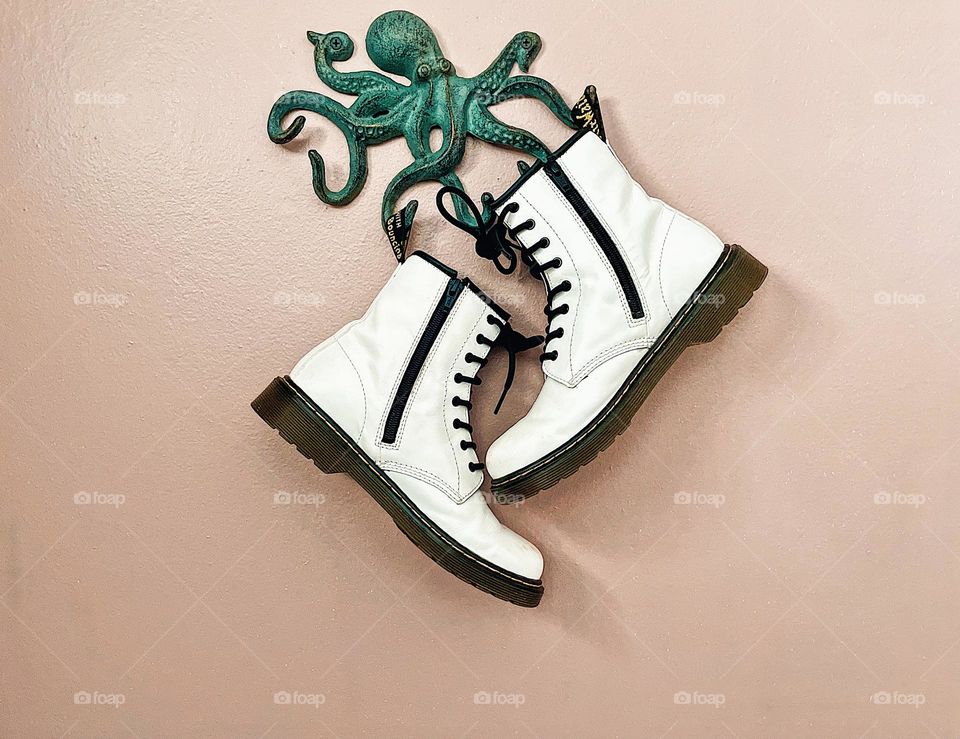 Metal octopus and white Doc Marten boots, Dr. Martin boots, octopus and boots, posed Docs on wall, hanging boots on wall, creative Doc Marten ad, advertisements for Doc Marten boots, white boots and green octopus 