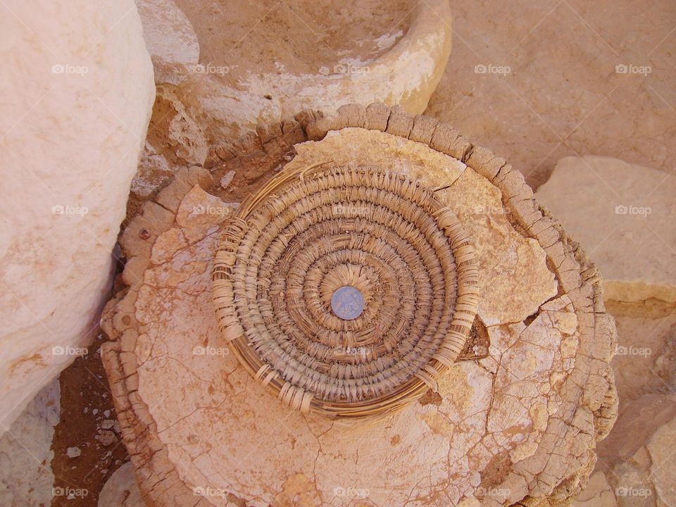 Interior of a cave house in Matmata, Tunisia - one of the remaining Berber settlements. Wicker bowl for coins left by tourists.