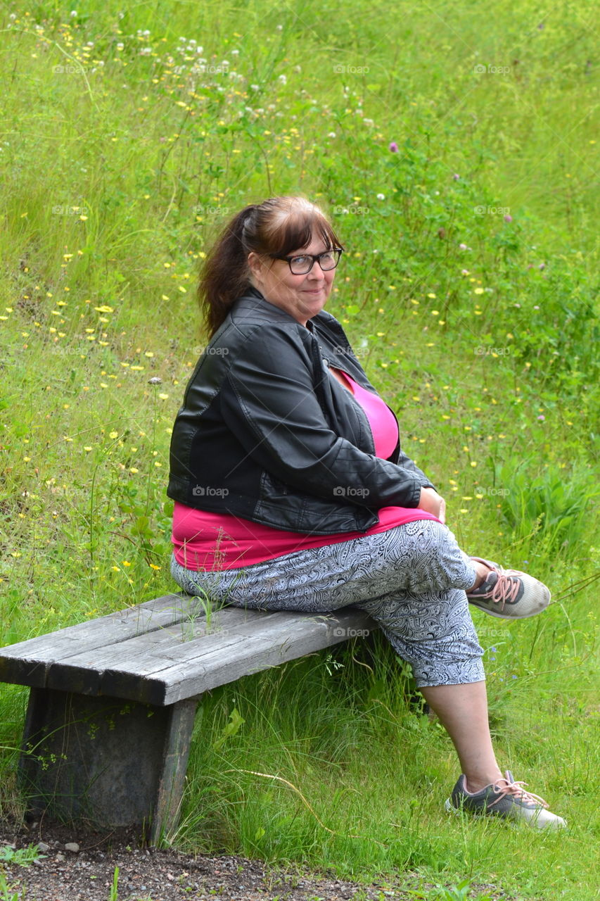 Smiling woman sitting on bench in park