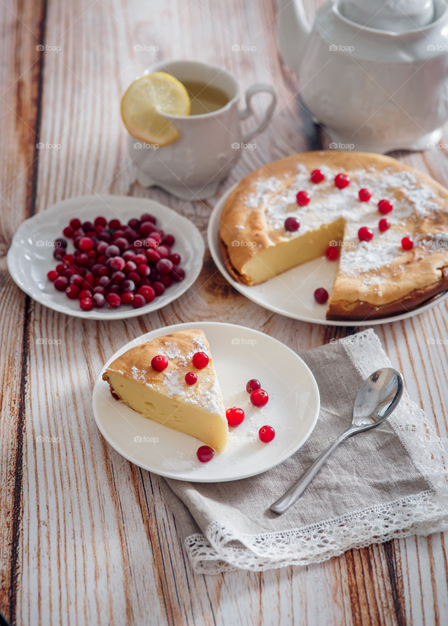 Cheesecake with cranberries and sugar on wooden background