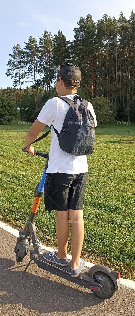 teenage boy on a electric scooter, summer time