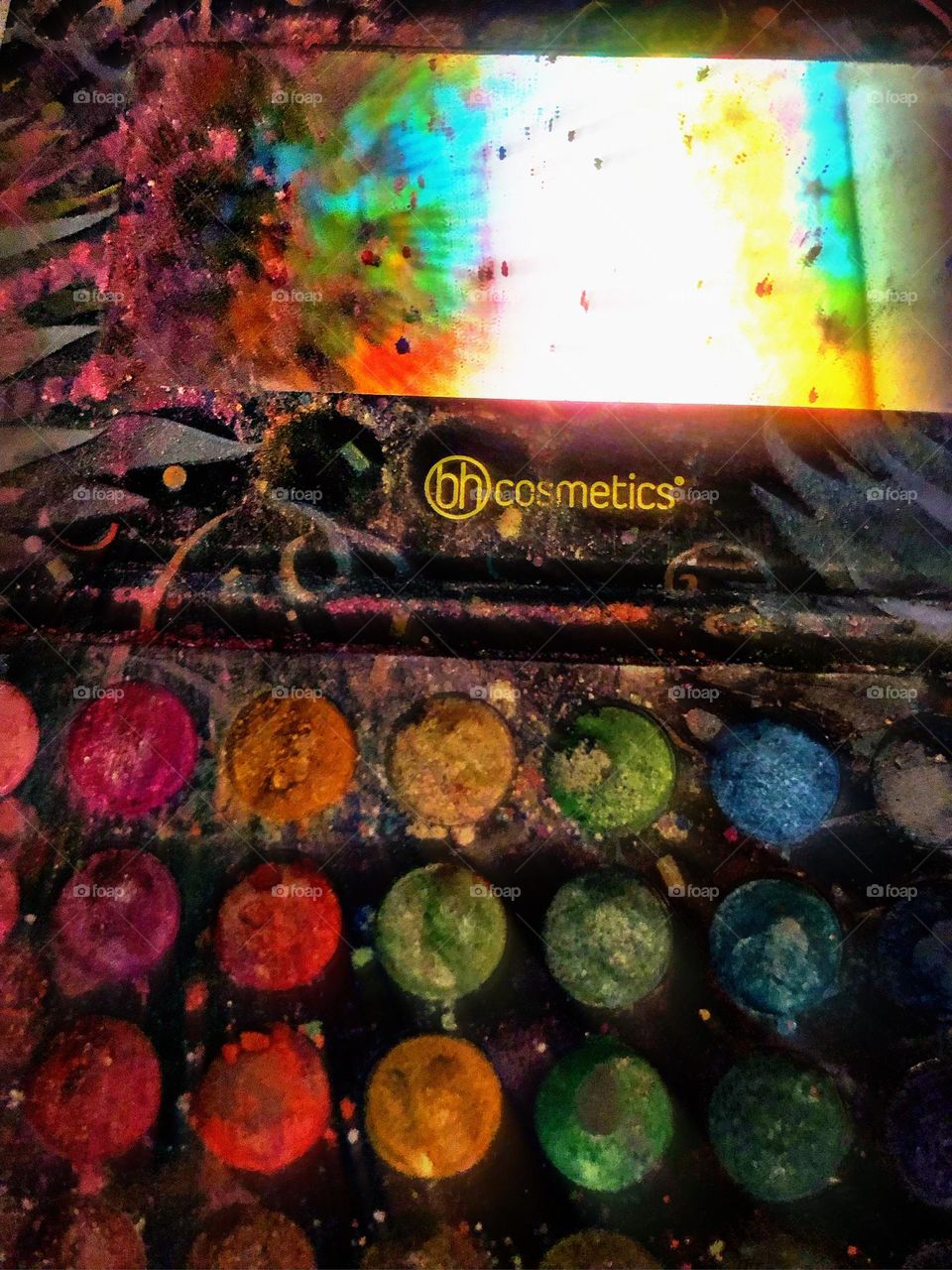 Bh cosmetics cosmetics makeup palette with a rainbow tapestry shining in the mirror