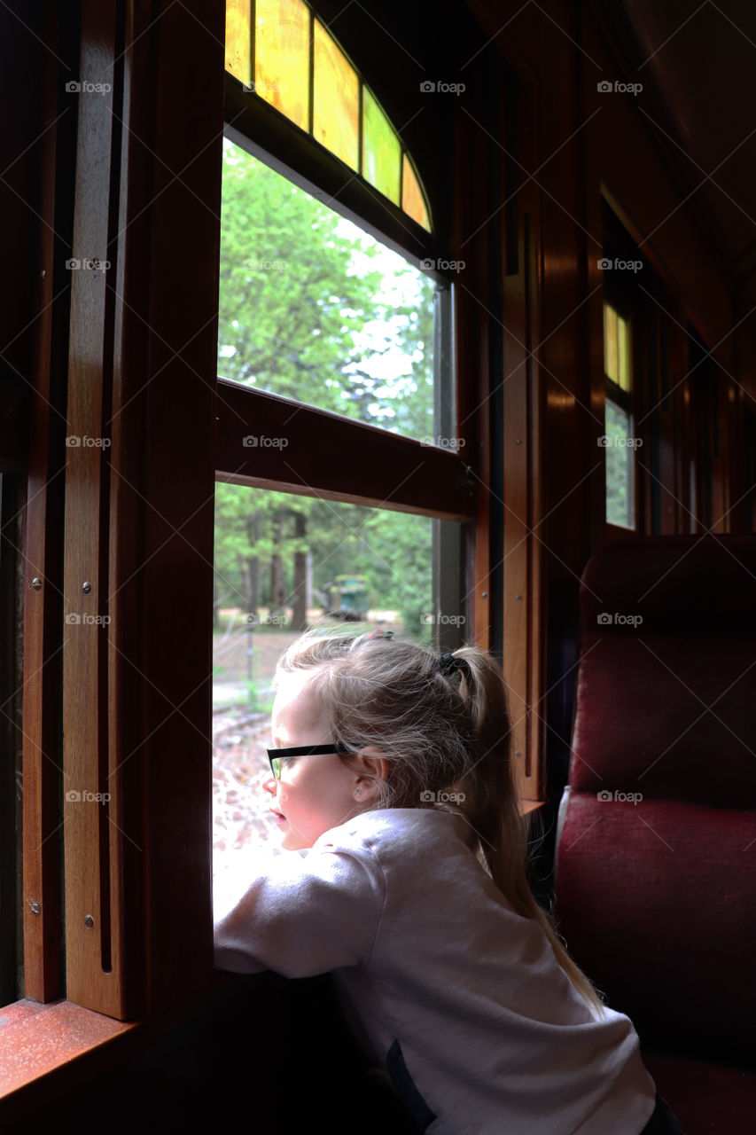 Child looking out a window from a train cart