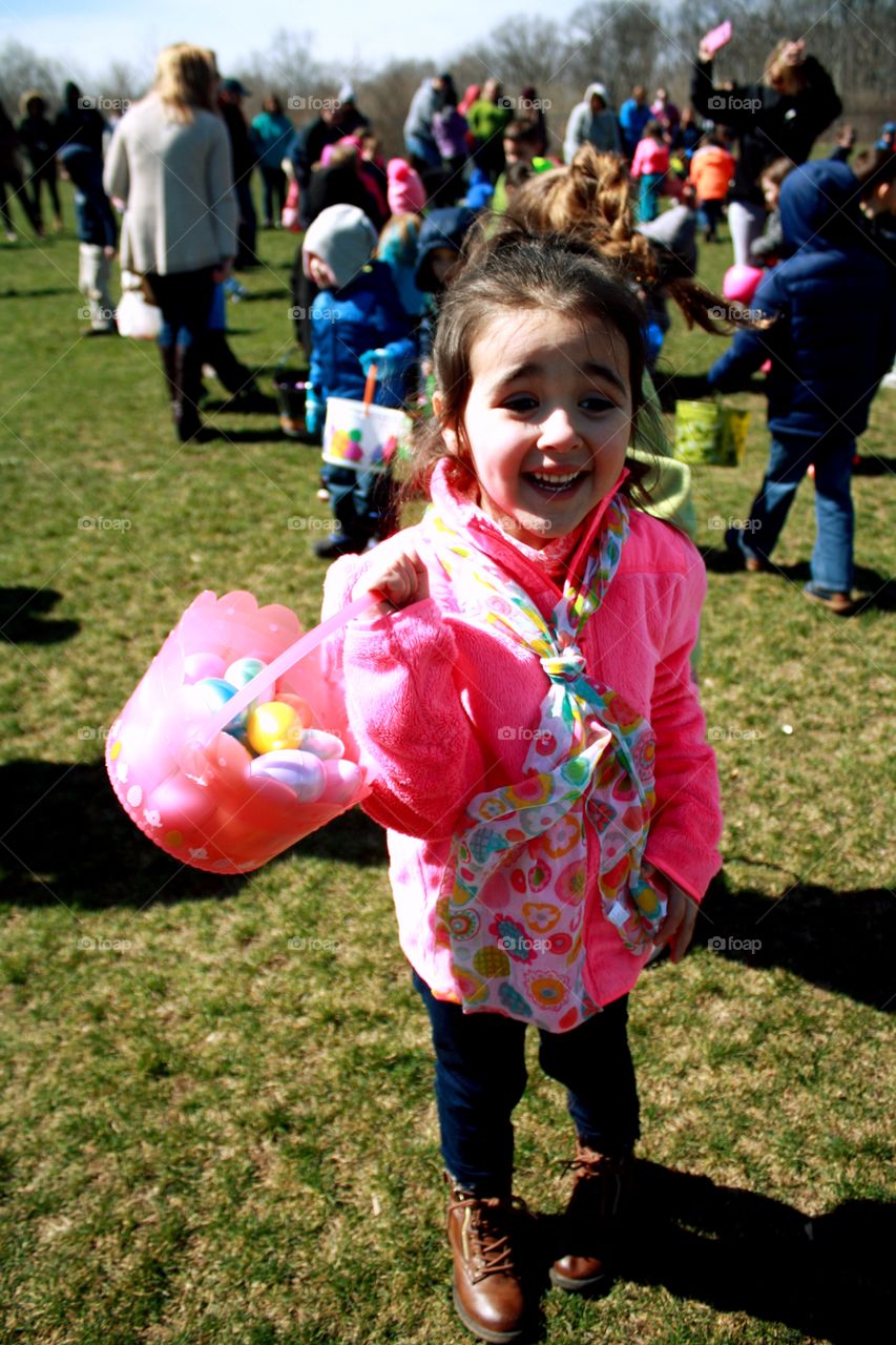 Cute girl holding basket of easter eggs