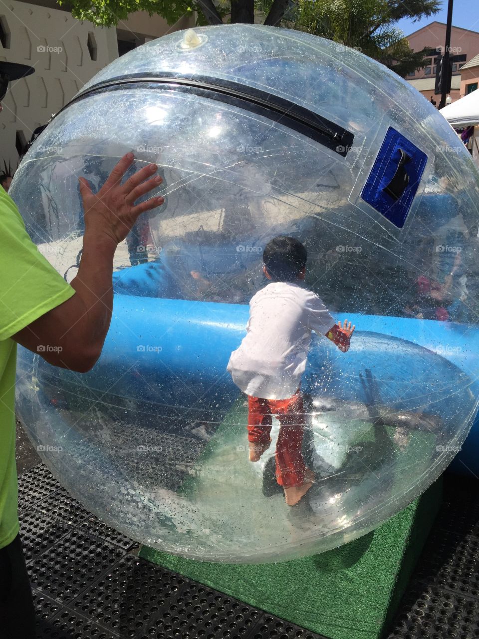 Kids having fun, playing with inflatable, transparent plastic  rolling ball in water