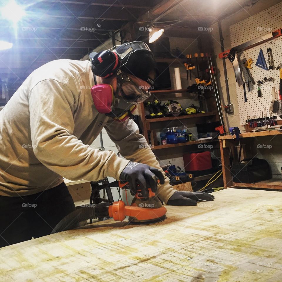 A carpenter carefully sands off decades of wear on a cherished family table in order to refinish the heirloom. 