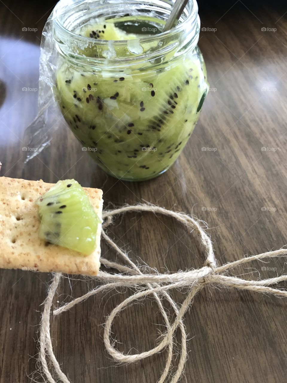Homemade kiwi jam with crackers on wooden table 