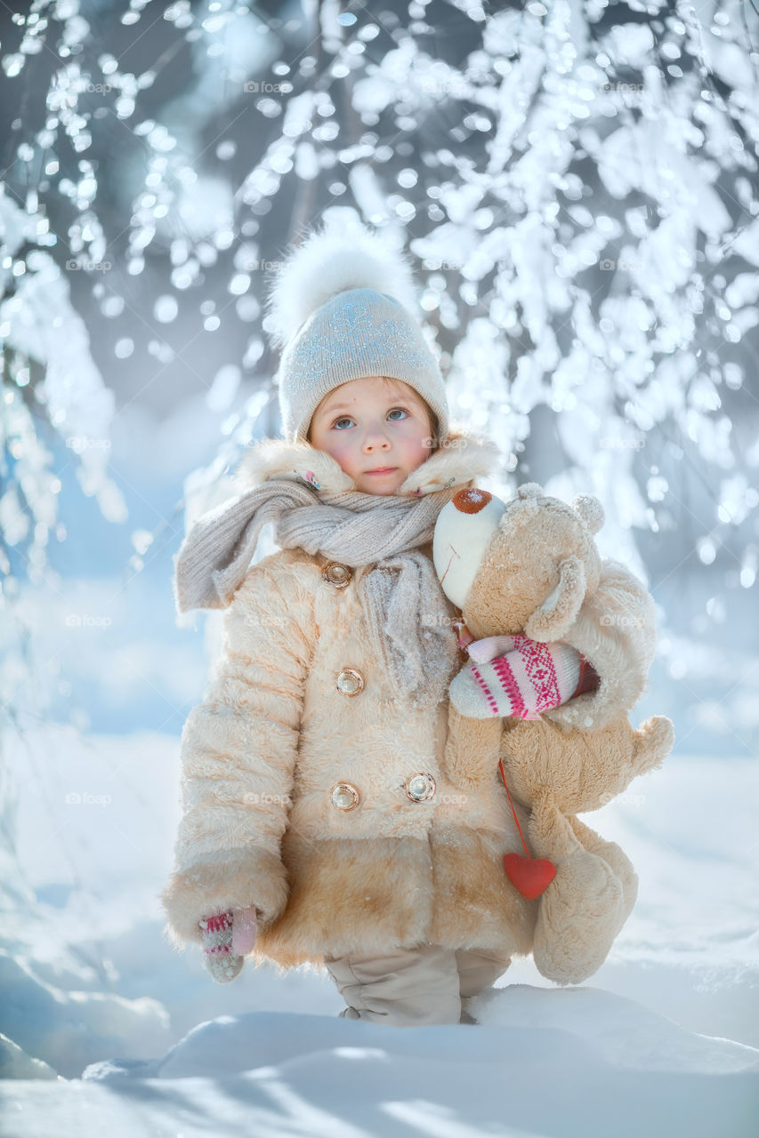 Little girl portrait with teddy bear, winter outdoor 