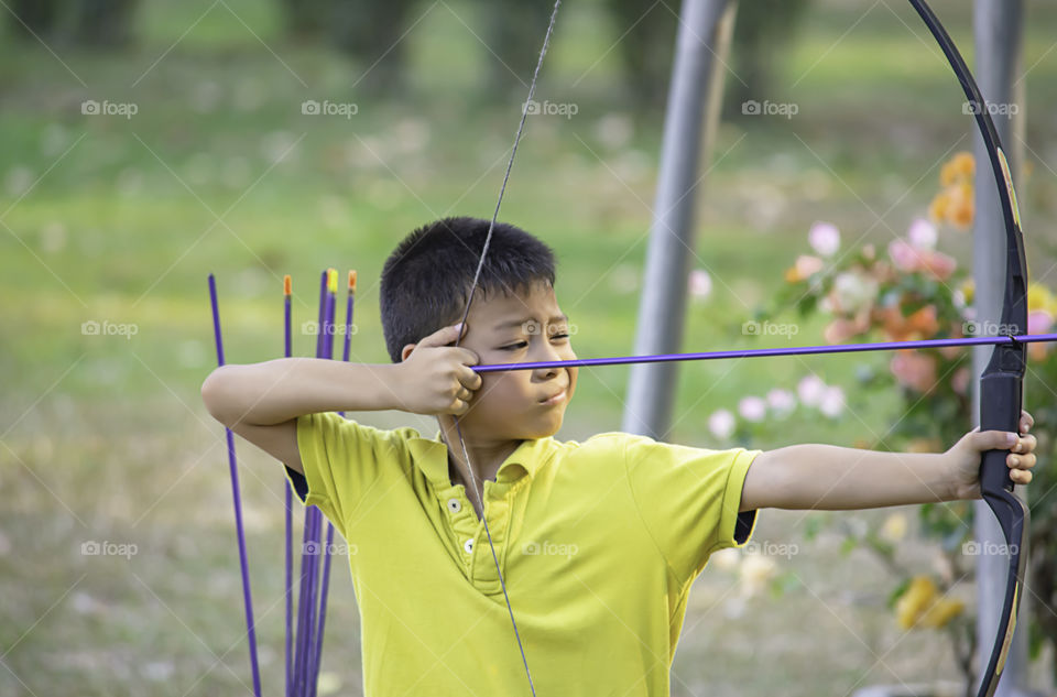 Asian boys are archery in camp adventure.