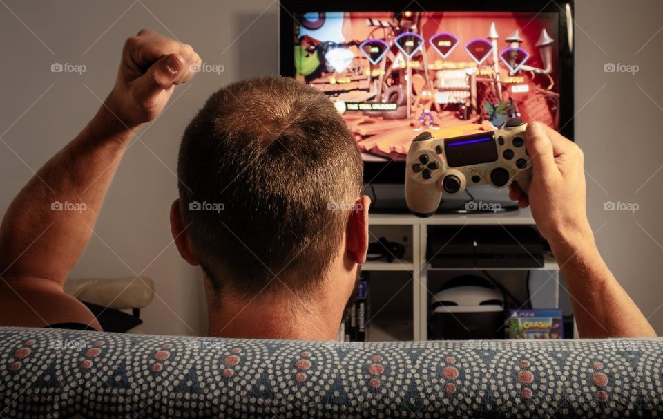 A man celebrates completing a level on a console game