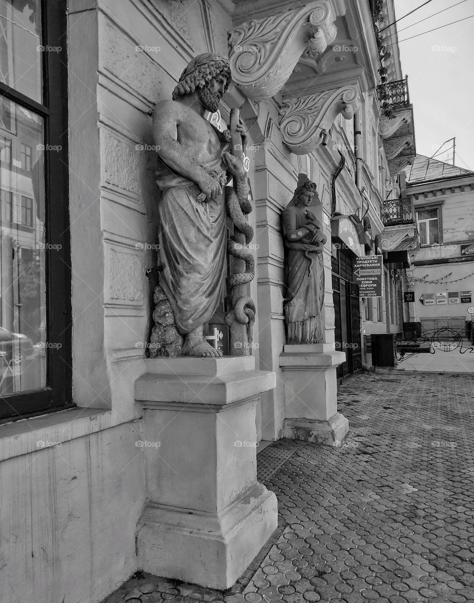 Sculptures of Asclepius and Panacea on the facade of one of the pharmacies in Chernivtsi