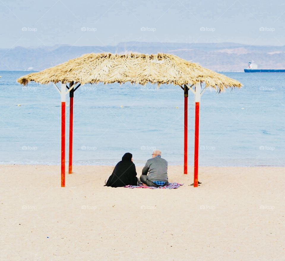 A couple sitting in the beach 