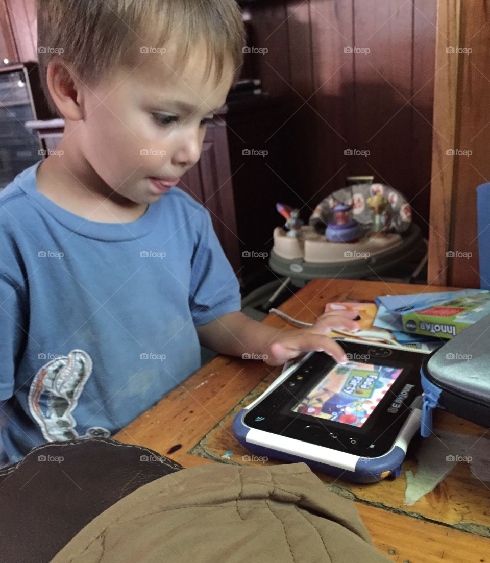 Boy playing game on digital tablet
