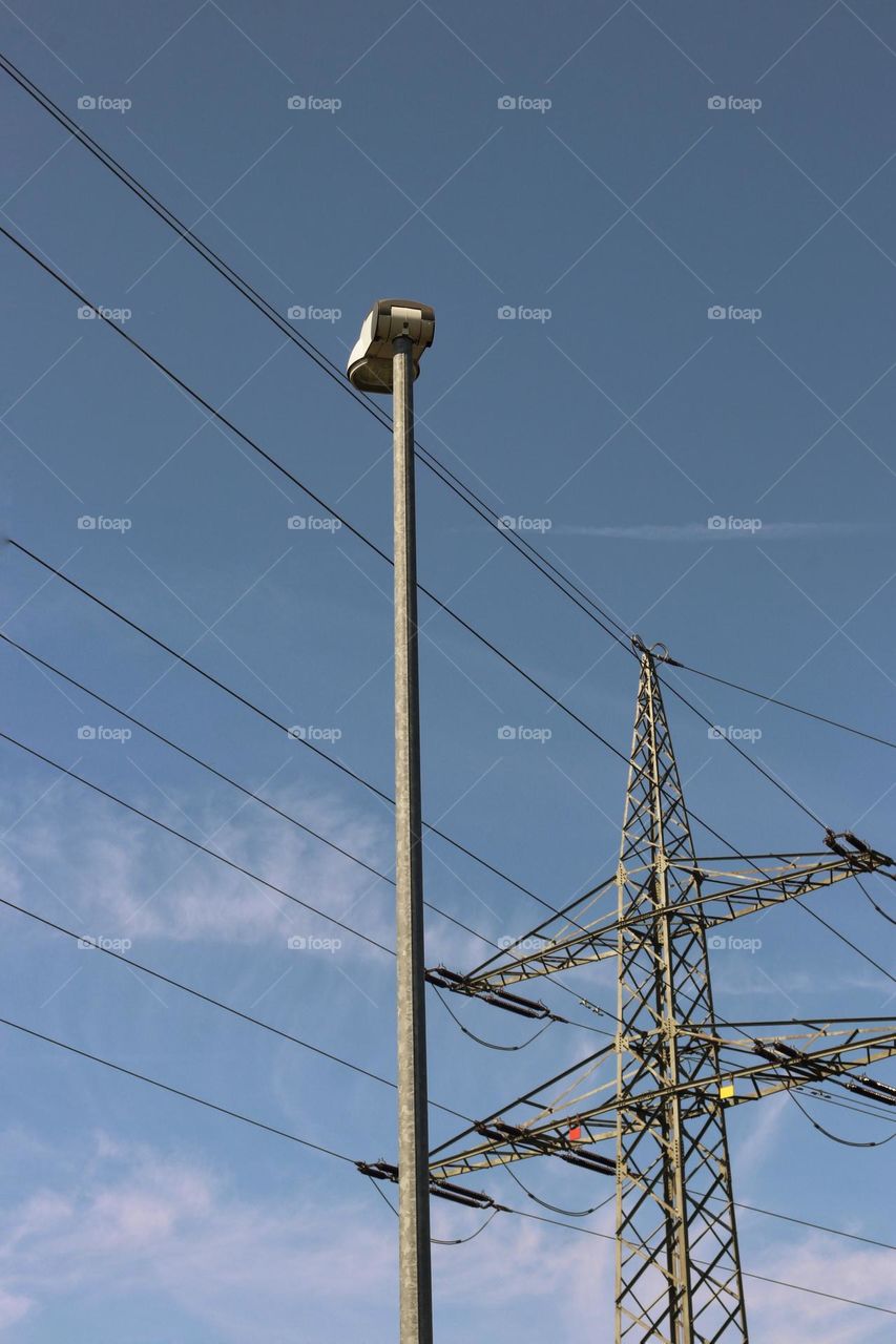 Street lamp and power pole against a blue sky