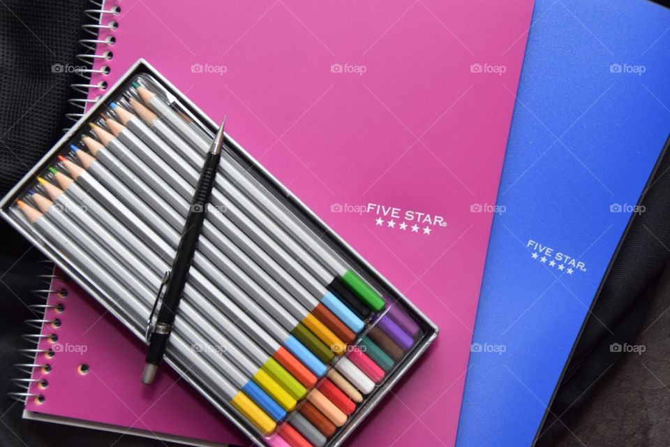 Five star spiral notebook and binder in blue and magenta with colored pencils