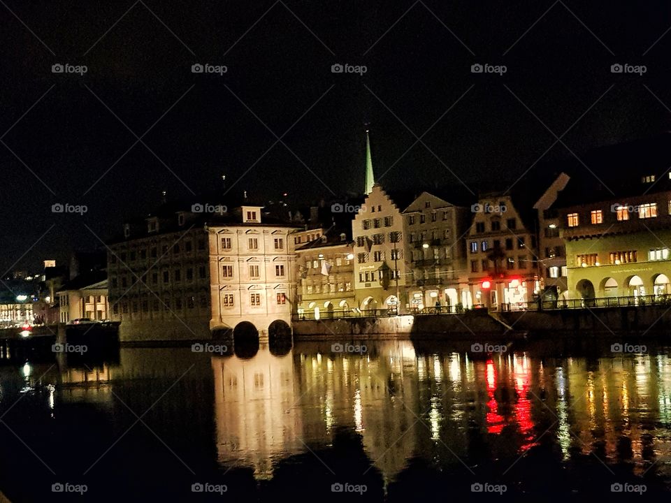 The town hall, the Niederdorf in the background and the Limmat river in the foreground in Zurich. Das Rathaus, das Niederdorf im hintergrund und die Limmat im Vordergrund in Zürich.