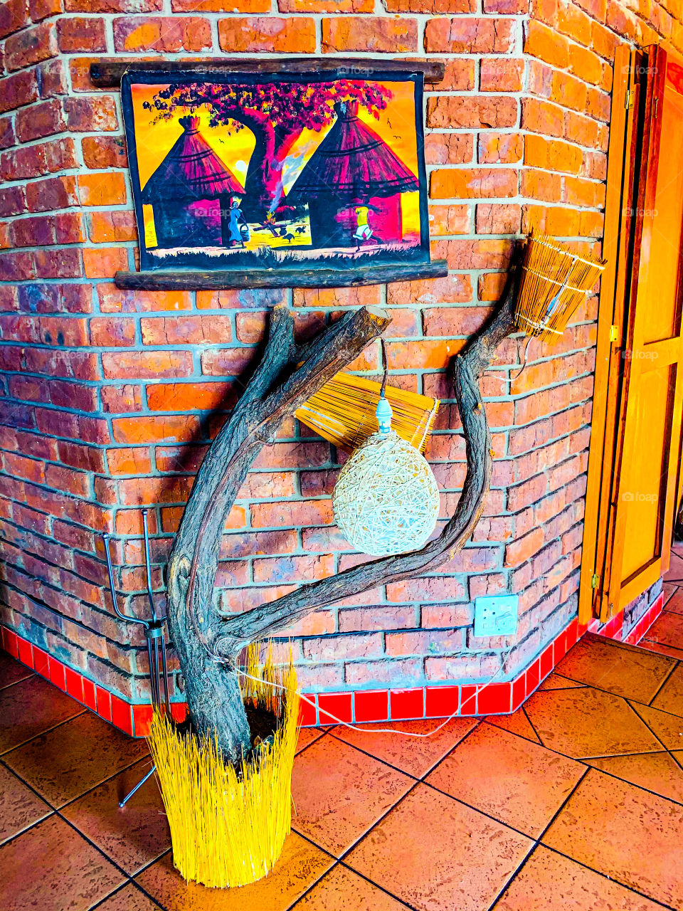 Natural natural made as a corner decoration in a restaurant corner. Dry timber as a tree with dry grass as a tree and bulb holder. With a homestead painting on top.