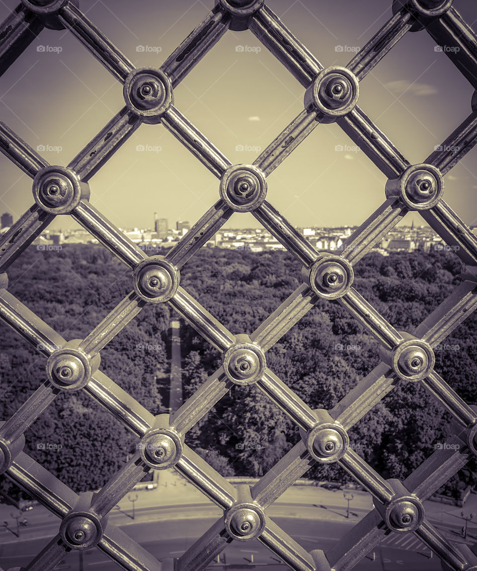Summer cityscape with park, road and clear sky, view from above through the iron lattice, center of Berlin, Tiergarten