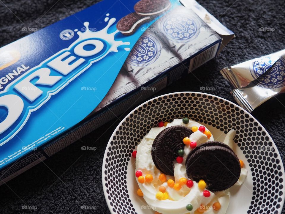 Oreo cookies with whipped cream and sprinkles.