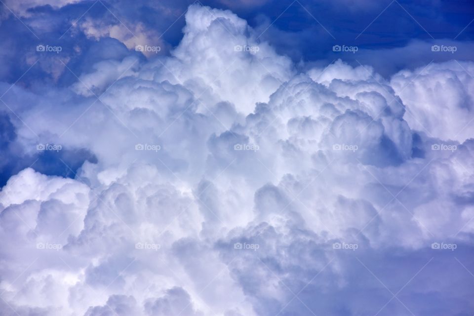 aerial view on fluffy clouds on the blue sky from plane window