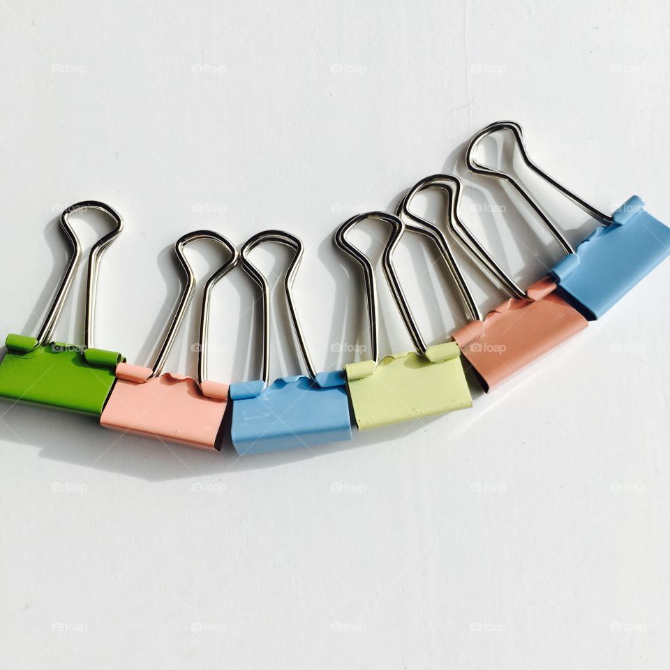 This is random , but very beautiful pastel paper clips on a white background . 