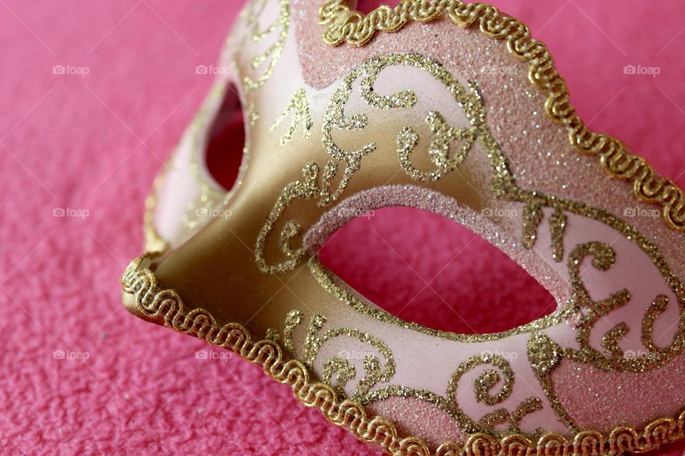 Golden mask on pink background 