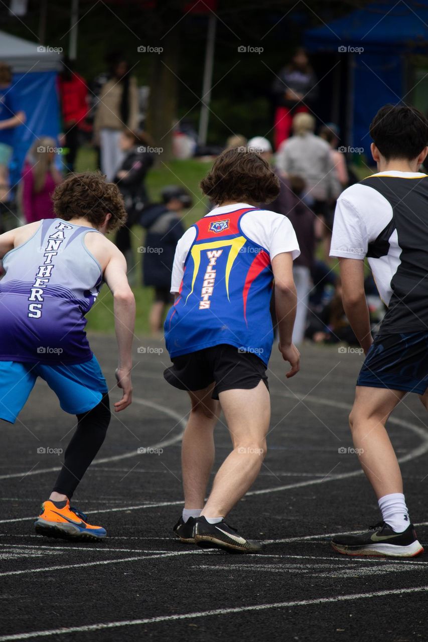 Three people at starting line for a track running race